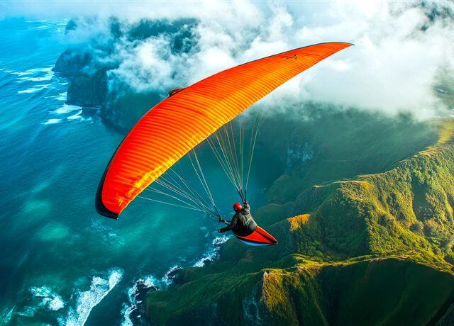 Paragliding adventure over green hills
