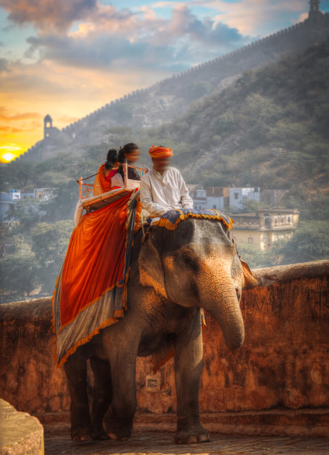 Travelers riding an elephant through a mountain valley